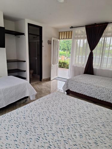 a bedroom with two beds and a sliding glass door at Finca Las Vegas in Aguazul
