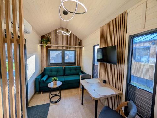 a living room with a green couch and a table at Tiny House WaldSEEle in Stuer