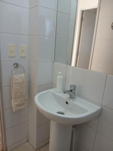 a white bathroom with a sink and a mirror at Casa Cómoda en La Cruz Quillota in La Cruz