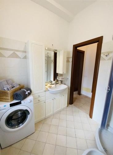 a bathroom with a washing machine and a sink at Appartamento da Mery in Asso
