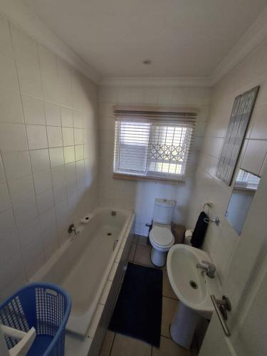 a bathroom with a tub and a toilet and a sink at Dadda's Place 2 in Port Shepstone