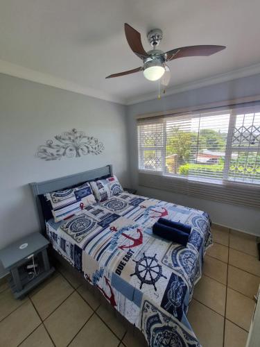 a bedroom with a bed and a ceiling fan at Dadda's Place 2 in Port Shepstone
