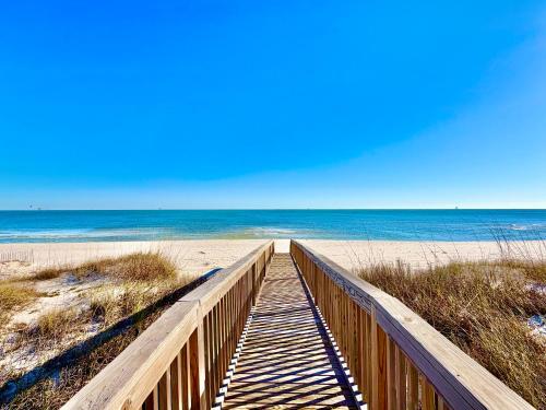 a wooden boardwalk leading to a beach with the ocean at Kinzalow Haven in Gulf Shores
