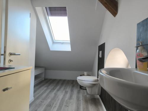a bathroom with a sink and a toilet and a window at Leuchtturmhus in Fürstenberg
