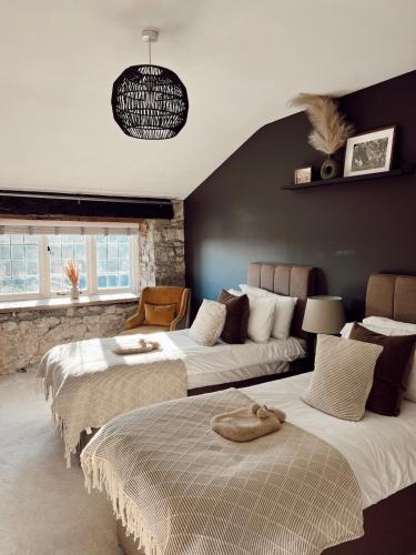 a bedroom with two beds and a couch at The Potting Shed at Mathern Palace in Chepstow