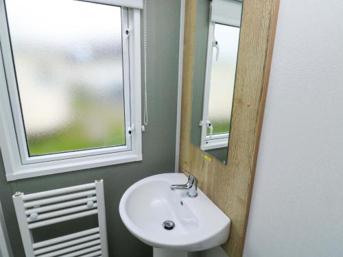 a bathroom with a sink and a mirror at The Foxy Cobbler in Kingsbridge