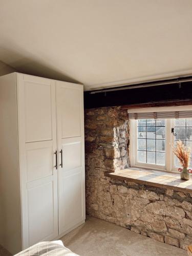 a room with a white cabinet and a window at The Potting Shed at Mathern Palace in Chepstow
