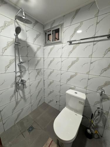 a bathroom with a toilet and a shower at Appartement moderne et épuré in Bonabéri