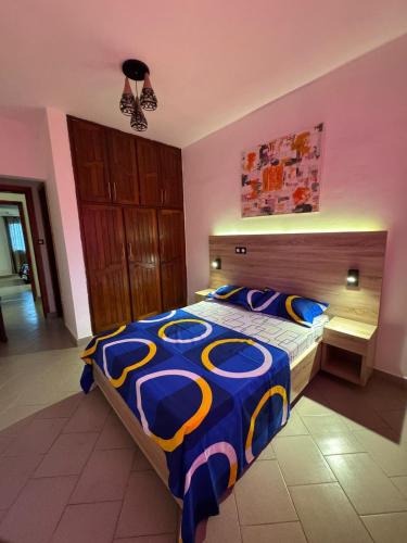 a bedroom with a bed with a blue and yellow comforter at Appartement moderne et épuré in Bonabéri