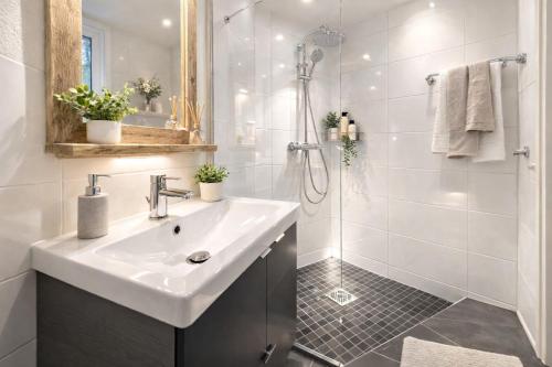 a white bathroom with a sink and a shower at Chalet Jägerstieg in Braunlage