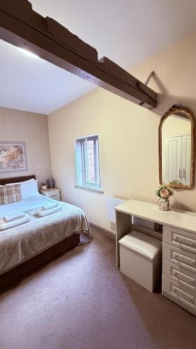 a bedroom with a bed and a desk and a mirror at Grant House in Boston
