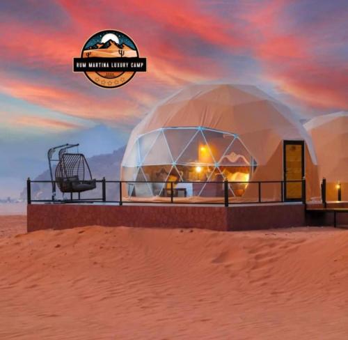a dome in the desert with a sunset in the background at RUM MARTiN BUBBLES lUXURY CAMP in Wadi Rum