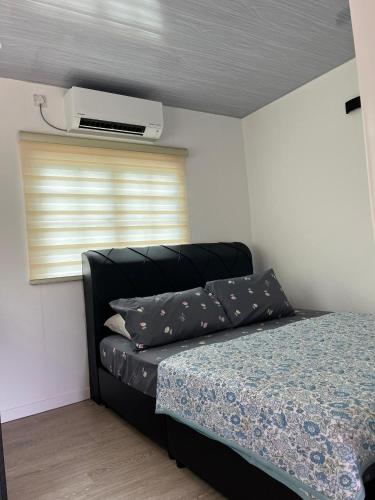 a bedroom with a bed and a air conditioner at Singgah Dusun Zahra in Kampong Perak