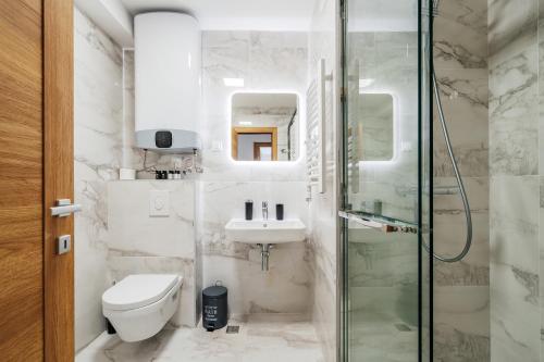a bathroom with a shower and a toilet and a sink at APART 28 - Premium Suites in Podgorica