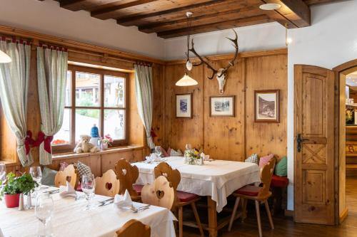 a restaurant with wooden walls and tables and chairs at Hotel Bischofsmütze in Filzmoos