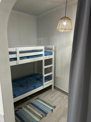 a room with two bunk beds and a chandelier at Casinhas à Beira Rio in Penacova