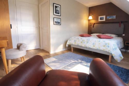 a bedroom with a bed and a couch and a chair at Pomme d'Happy in Autheux