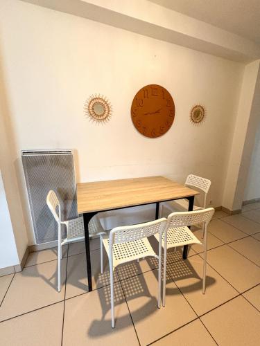a table with two chairs and a clock on the wall at À Quelques pas de la gare - Duplex in Sartrouville