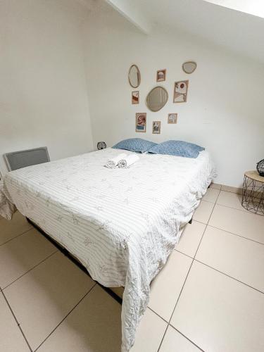 a bedroom with a bed with a white comforter at À Quelques pas de la gare - Duplex in Sartrouville