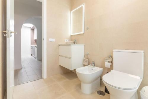 a white bathroom with a toilet and a sink at Nice Bungalow with Two Bedrooms in Adeje