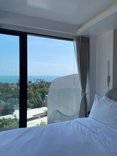 a bedroom with a bed and a large window at The Blue Lion Villa Samui in Chaweng Noi Beach