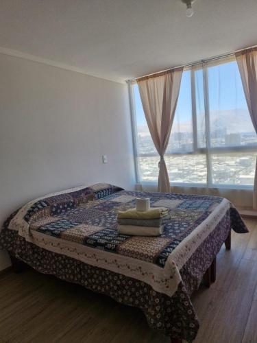 ein Schlafzimmer mit einem Bett und einem großen Fenster in der Unterkunft edificio libertad Iquique con vista y wifi in Iquique