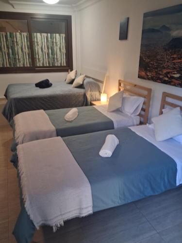 a hotel room with three beds with towels on them at casa cairasco in Las Lagunas