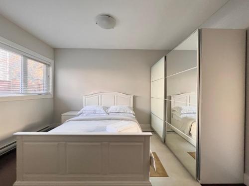 a bedroom with a white bed and a mirror at Spacious Home in Richmond in Richmond