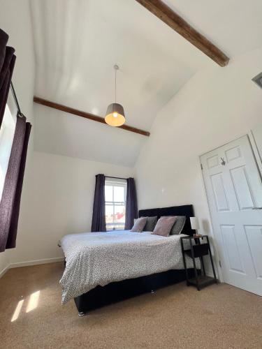 a bedroom with a bed and a window at The Old Rope Works in Woburn Sands