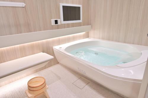 a bathroom with a large tub in the corner at 愛敬家 in Mobara