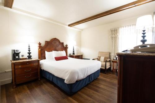 a hotel room with a bed and a telephone at Fireside Inn and Suites Bangor in Bangor