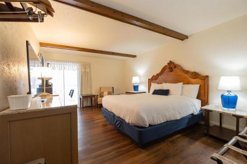 a bedroom with a large bed with a wooden headboard at Fireside Inn and Suites Bangor in Bangor