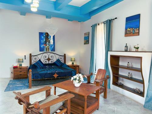 a bedroom with a bed and a table and chairs at Résidence Soros - Île de Gorée in Dakar