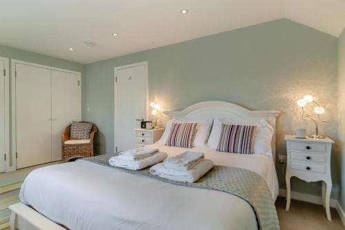 a bedroom with a large white bed with towels on it at 3 Bed in Knodishall oc-wbco in Aldringham