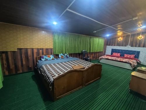 a bedroom with two beds and green carpet at Shamus Javed Homestay in Srinagar