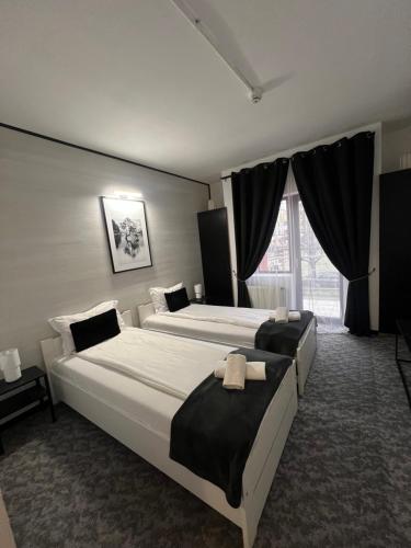 a hotel room with two beds and a window at PENSIUNEA UNO in Timişoara