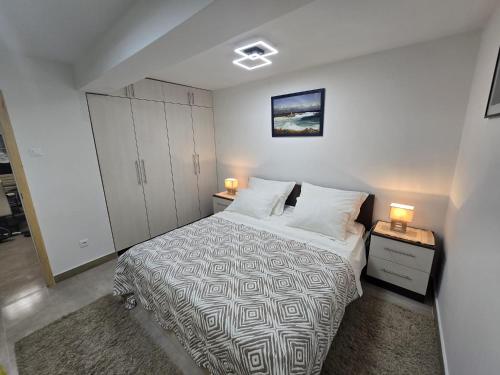 a bedroom with a bed and two lamps on tables at Infinity Blue Korčula in Korčula