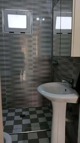 a bathroom with a sink and a mirror at Ka'Zinha Guesthouse - Chambres d'hôtes Tarrafal in Tarrafal