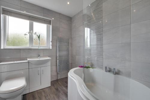 a bathroom with a tub and a toilet and a sink at 3 Bed in Ravenscar oc-sa397 in Ravenscar