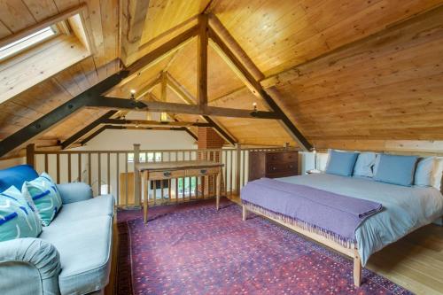 a bedroom with a bed and a couch in a attic at 3 Bed in Debenham oc-thefol in Debenham