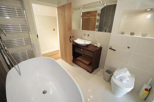 a bathroom with a tub and a sink and a toilet at 4 Bed in Gower oc-hh471 in Llanmadoc