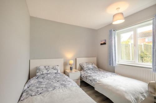 two beds in a bedroom with a window at 2 Bed in Reedham oc-2378 in Haddiscoe