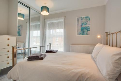 a bedroom with a large bed with two towels on it at 3 Bed in Winterton-on-Sea oc-2205 in Winterton-on-Sea