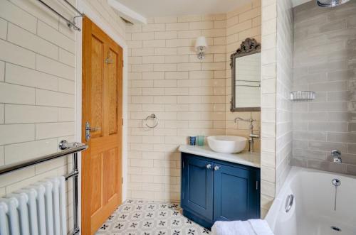 a bathroom with a blue door and a sink and a tub at 3 Bed in Fowey oc-p00647 in Fowey