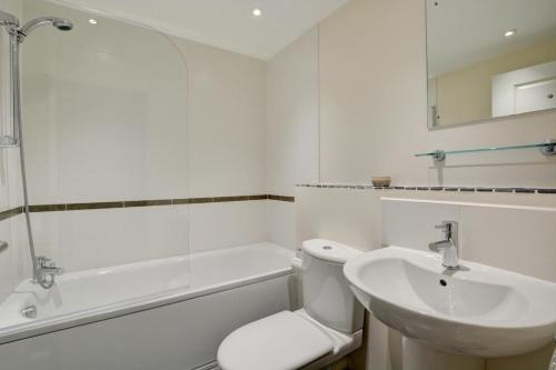 a white bathroom with a toilet and a sink at 4 Bed in Cromer oc-1942 in Cromer