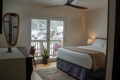 a bedroom with a bed and a view of a balcony at The Perch Hotel in East Windham