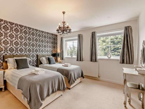 a bedroom with two beds and a chandelier at 6 Bed in Morpeth oc-91805 in Ellington