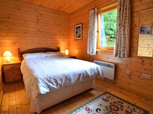 a bedroom with a bed in a log cabin at 3 Bed in Glenfinnan oc-cabin in Glenfinnan