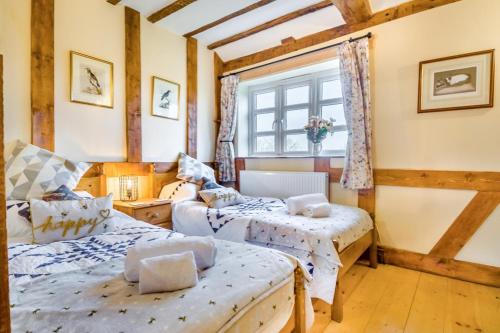 two beds in a room with a window at 3 Bed in Gressenhall oc-o28417 in East Dereham