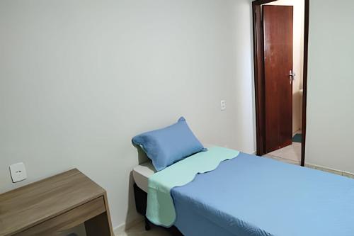 a bedroom with a blue bed and a mirror at Refúgio Hostel Unidade 3 in Bauru